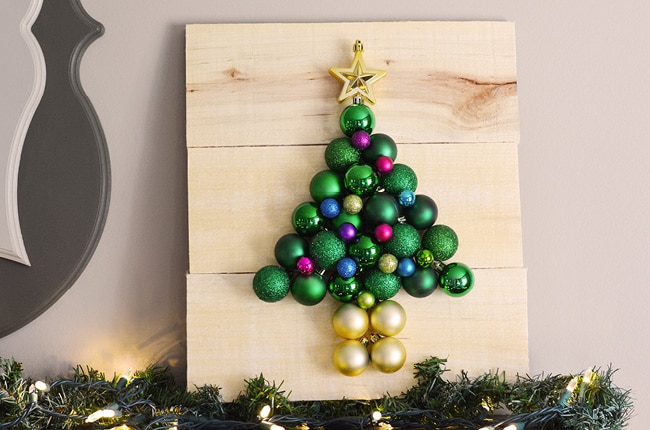 Grab some inexpensive plastic ornaments and a few pallet boards and you can make this pallet Christmas tree that is guaranteed to never drop needles!
