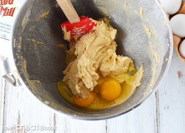 Mixing in eggs and butter with sugar in a stainless steel mixing bowl