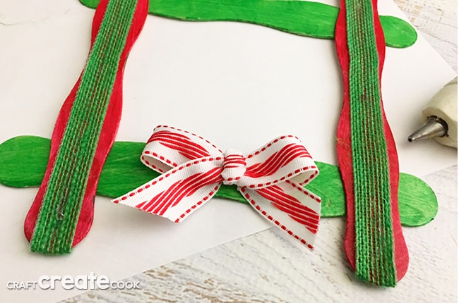 Our Craft Stick Christmas Ornament is easy to make and looks great on the Christmas tree or on top of gifts.