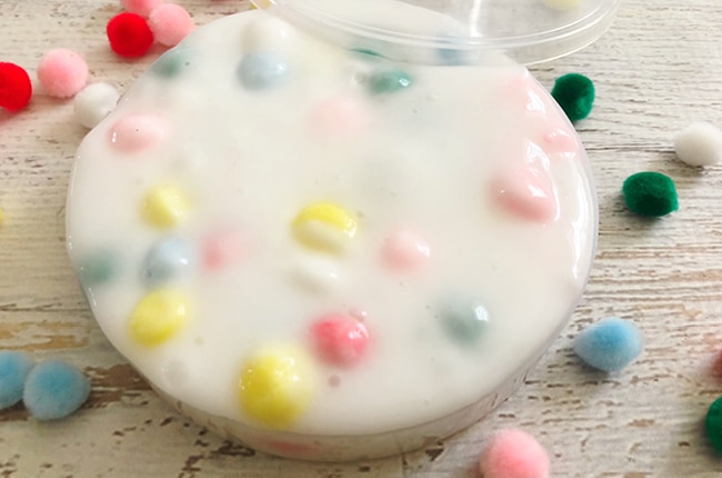 Our Sensory Slime is the perfect gooey slime with colorful pom pom balls for fun.