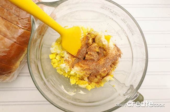 Mixing all the ingredients for the egg sandwich recipe in the glass bowl.