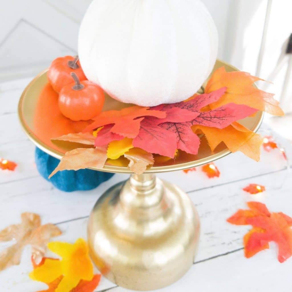 Gold stand with pumpkin and leaves