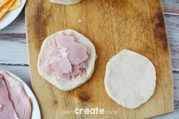 Adding ham to biscuit