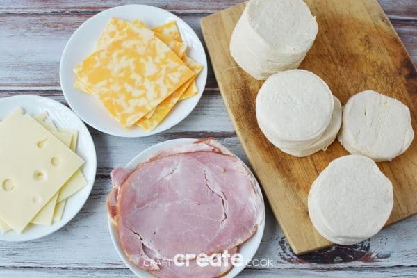 Ingredients for ham and cheese biscuit sandwiches on cutting board