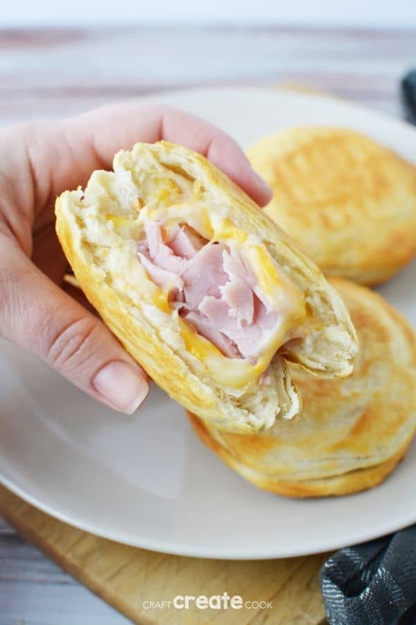 Biscuit sandwiche held above white plate