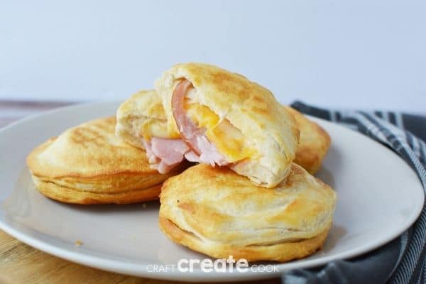 Stack of ham and cheese biscuits on white plate